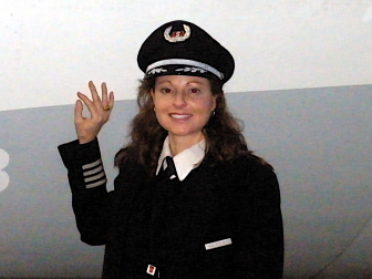 Closeup of Gina in her Captain's uniform standing next to a CRJ.